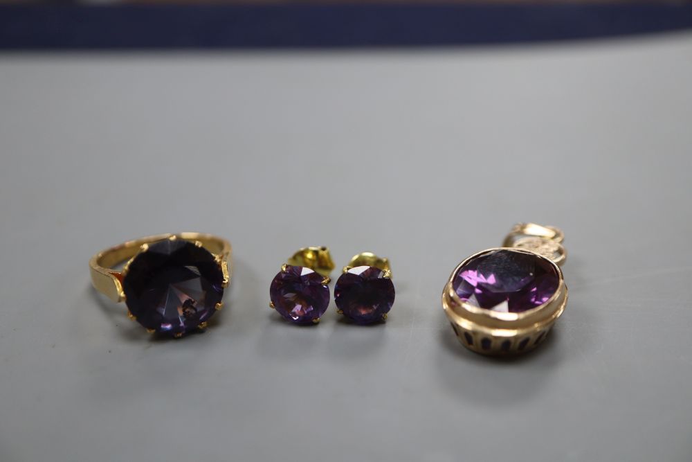 A 14k and synthetic colour change corundum pendant, a pair of similar earrings and a similar yellow metal dress ring, size M